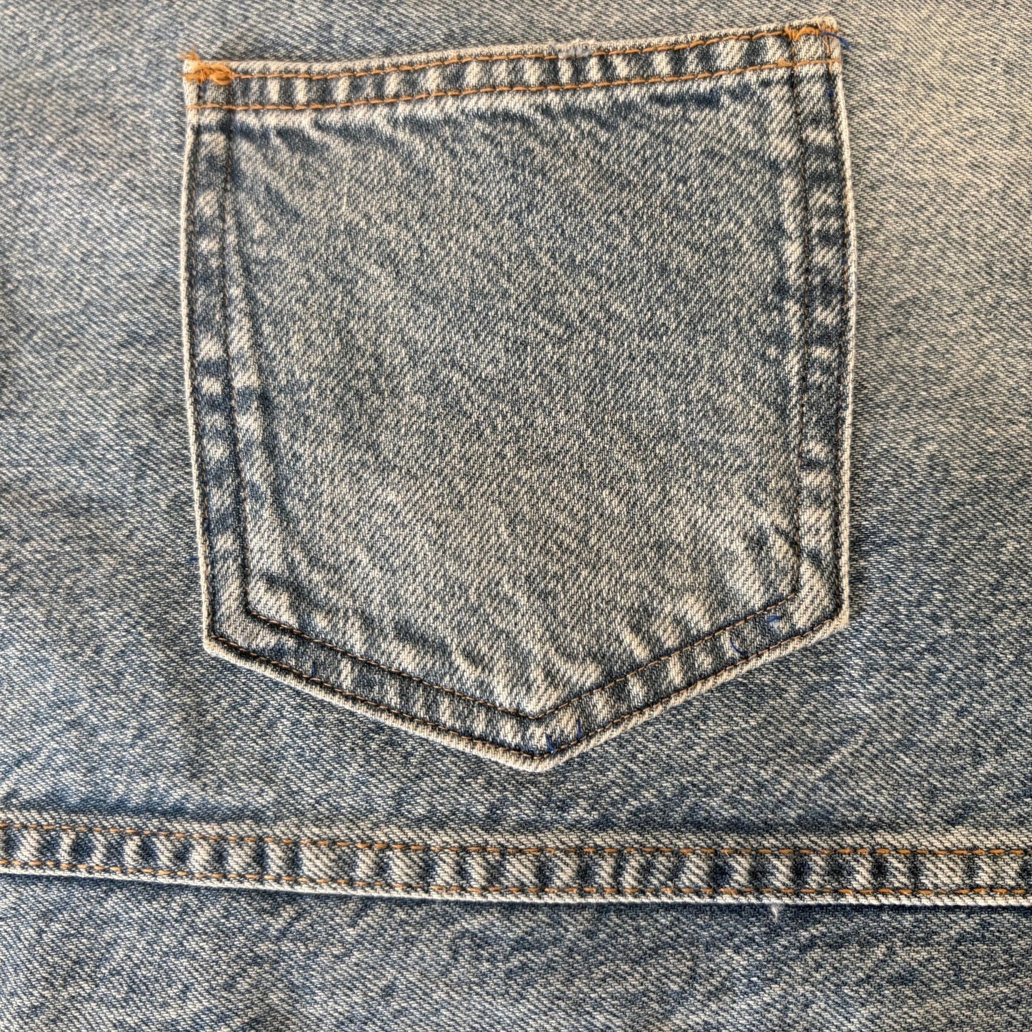 Close-up of a blue denim pocket with stitching details