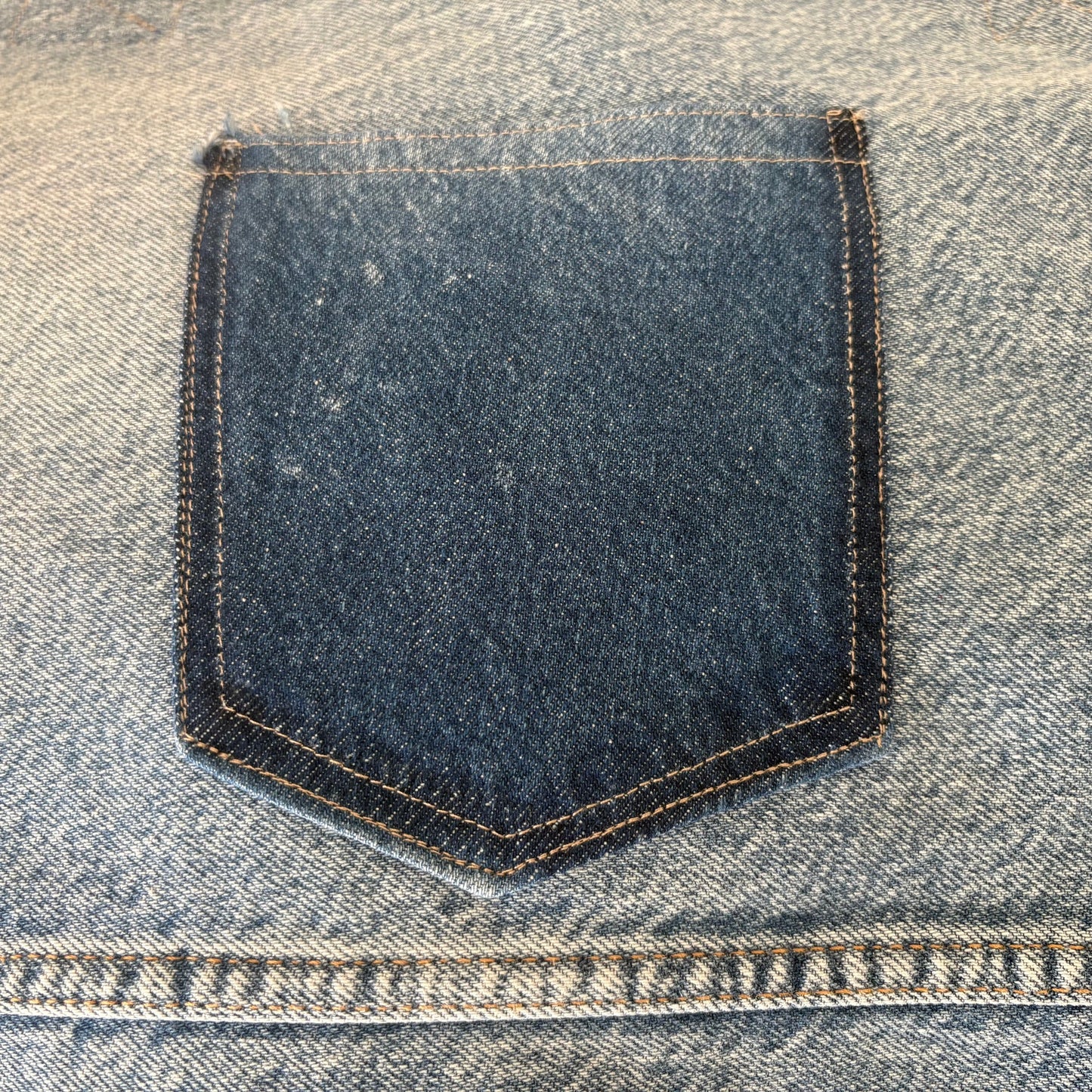 Close-up of a blue denim pocket on a jeans fabric.